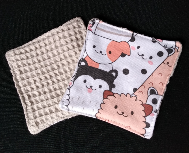 Lingette démaquillante. Une face en coton nid d'abeille beige et une face en coton imprimé chiens blanc, saumon et noir.