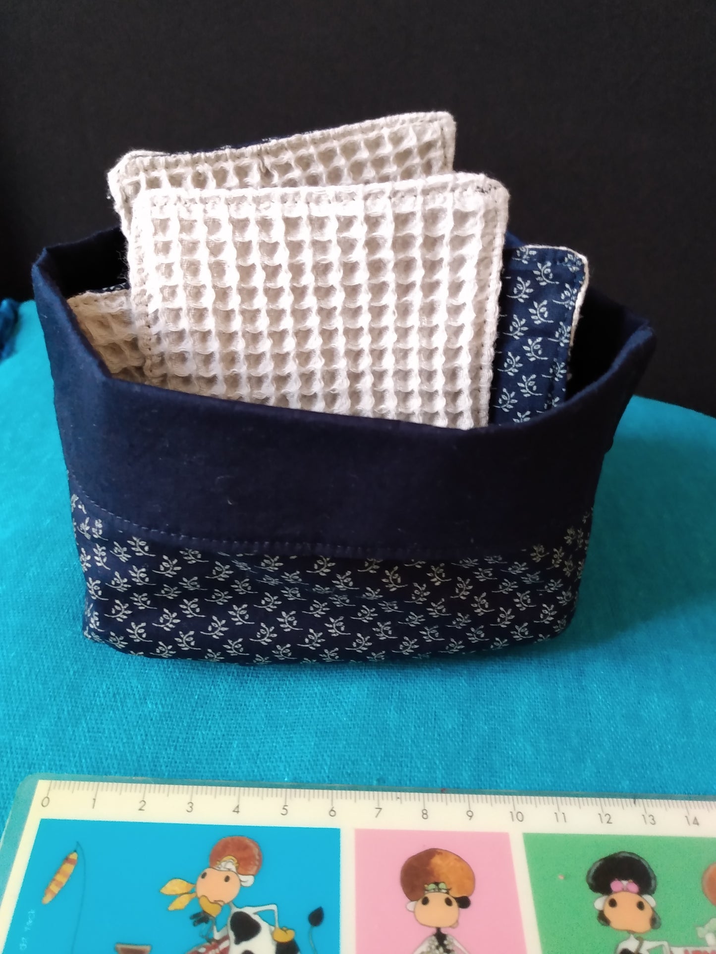 Panier avec six lingettes démaquillantes assorties, en coton bleu marine imprimé épis de blé. Les lingettes possèdent une face absorbante en coton nid d'abeille