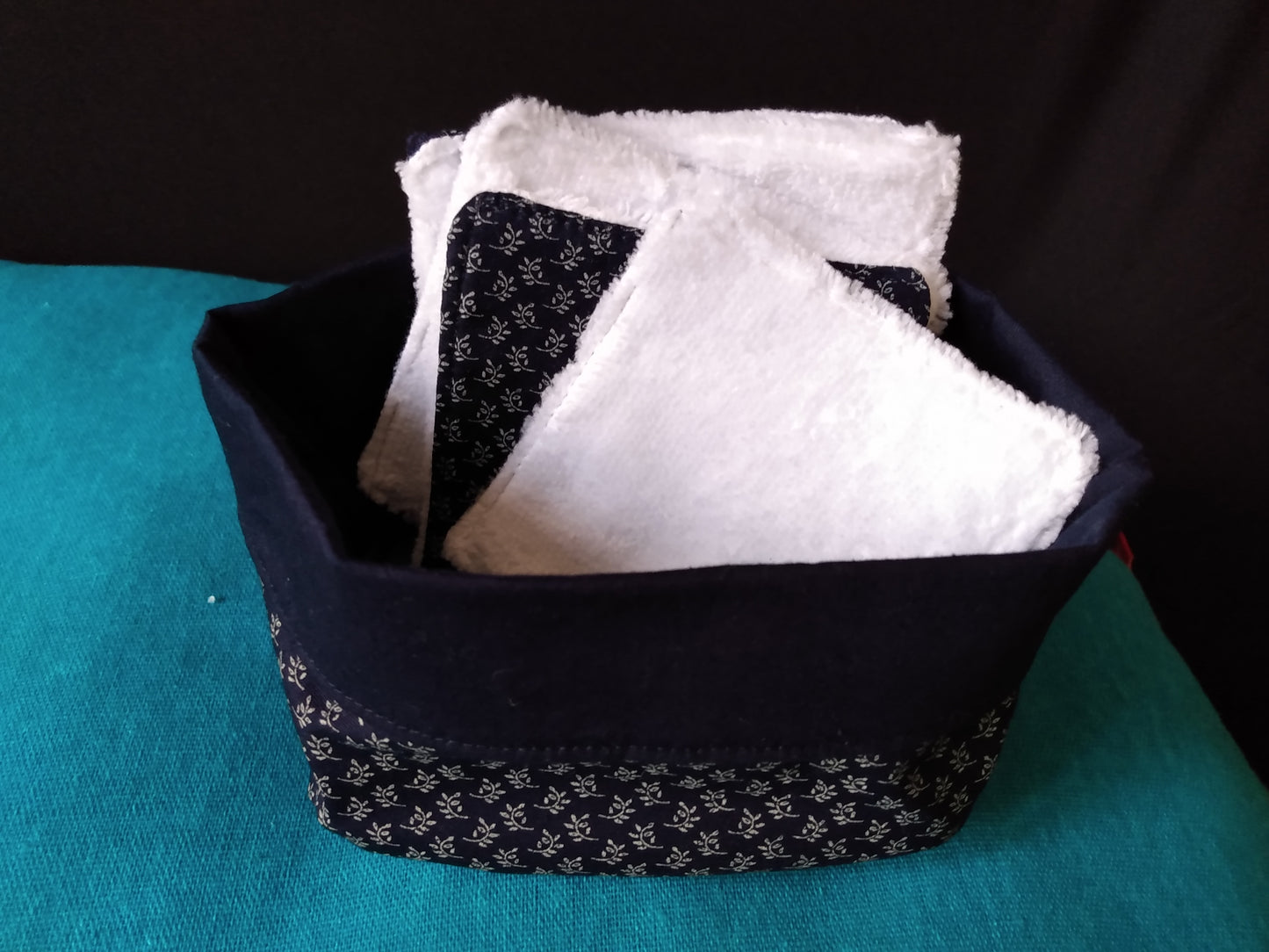 Panier avec 6 lingettes démaquillantes à l'intérieur. Lingettes avec une face éponge blanche et une face coton bleu marine imprimé épis de blé. Le panier est assorti aux lingettes.