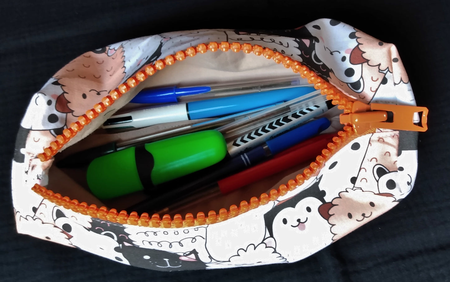 Trousse taille 2 imprimé chiens ouverte. Cela laisse apparaitre la doublure gris clair.