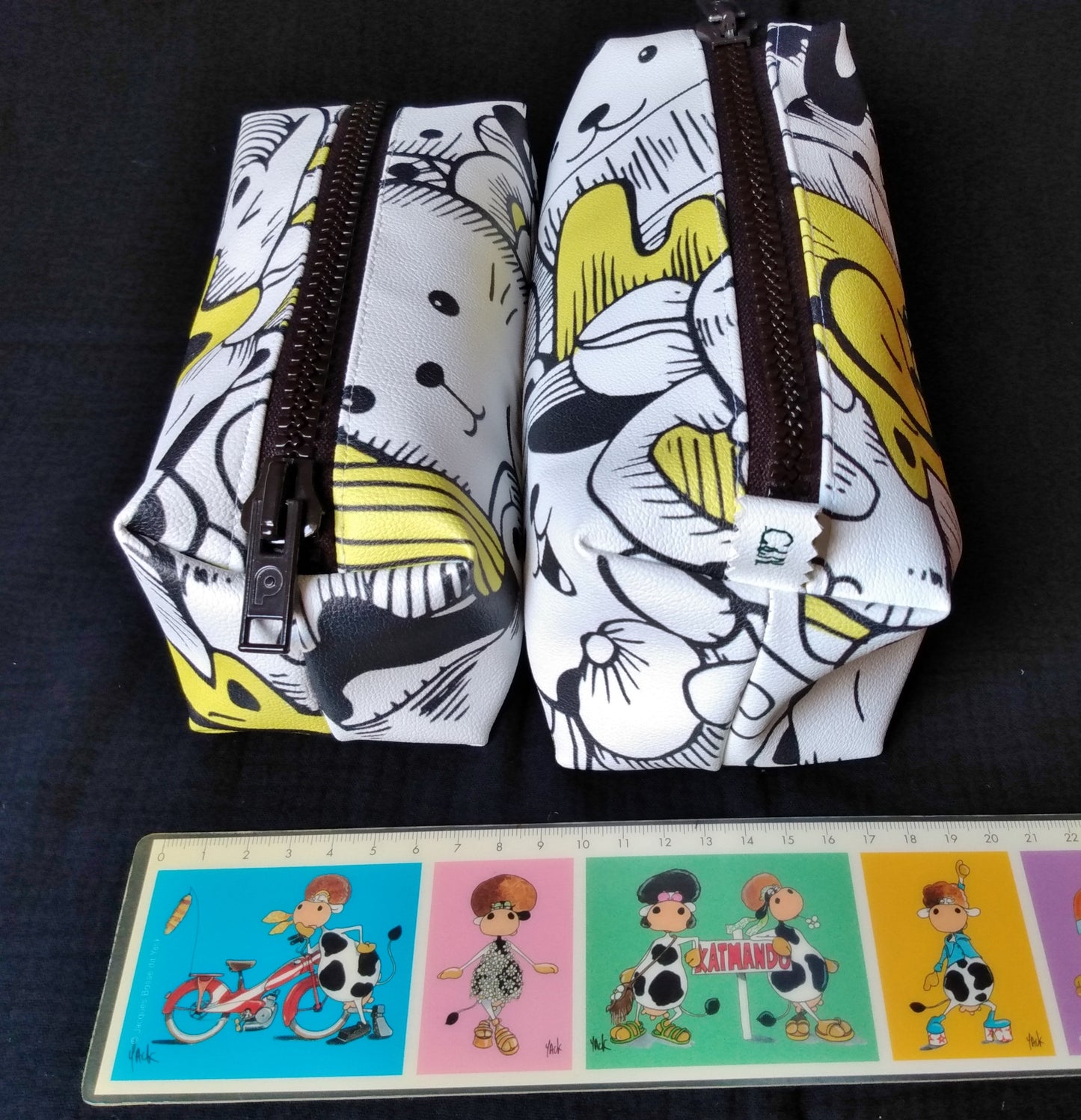 comparaison entre deux trousses à imprimé chats jaune et blanc, une trousse taille 1 et une trousse taille 2 (plus grande)