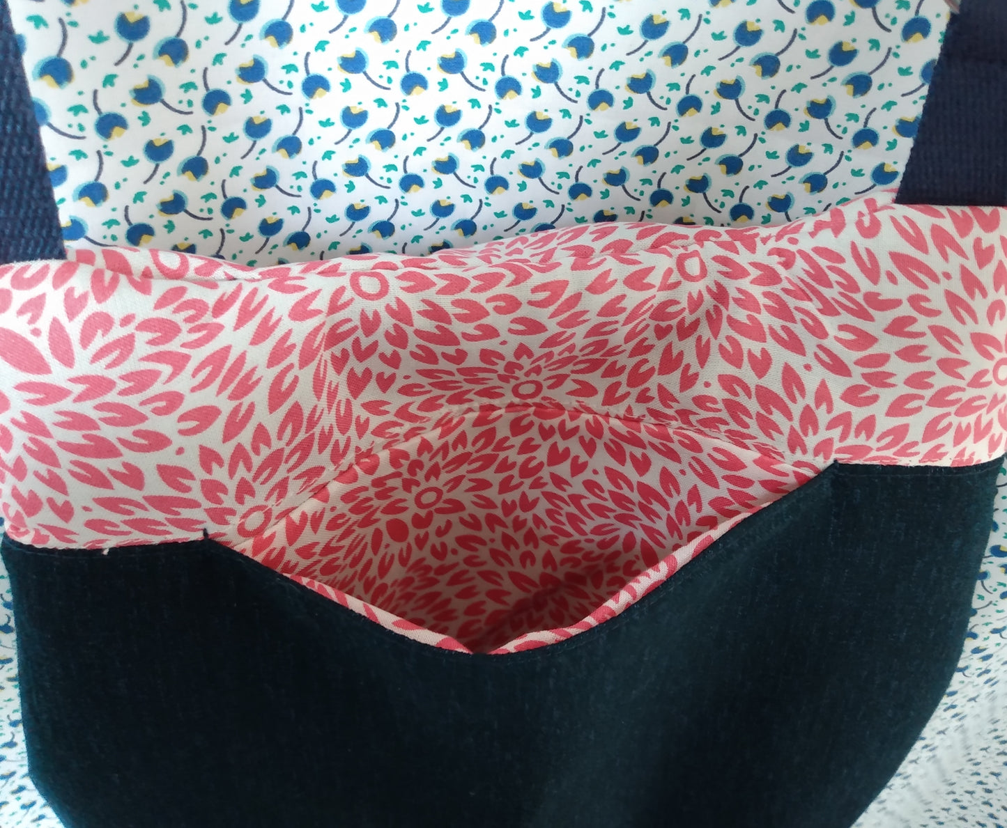 vue arrière du sac pivoine bleu marine. Une poche ouverte est visible. Le haut du sac est en coton beige à fleurs roses, le bas en tissu bleu marine.