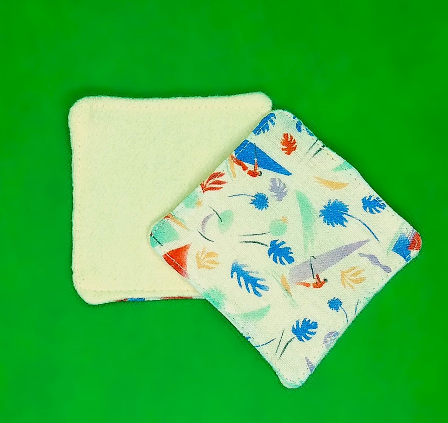 Lingette démaquillante. Une face en molleton de chanvre beige et une face en coton imprimé plances à voiles et feuilles coloris pastel sur fond beige.