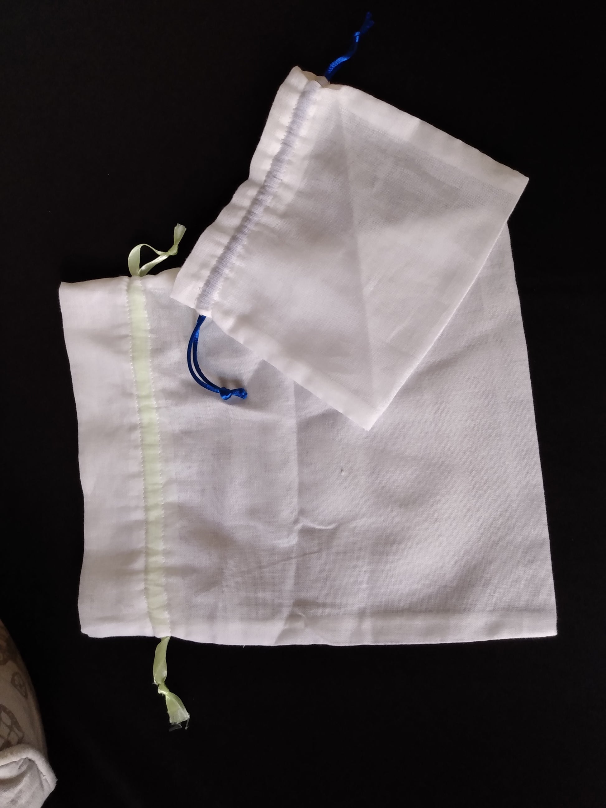 Vus sur un sac à vrac grande taille et un sac à vrac petite taille. Ils sont de couleur blanche et transparents. La fermeture se fait avec un cordon (ou un ruban) glissé dans une coulisse..