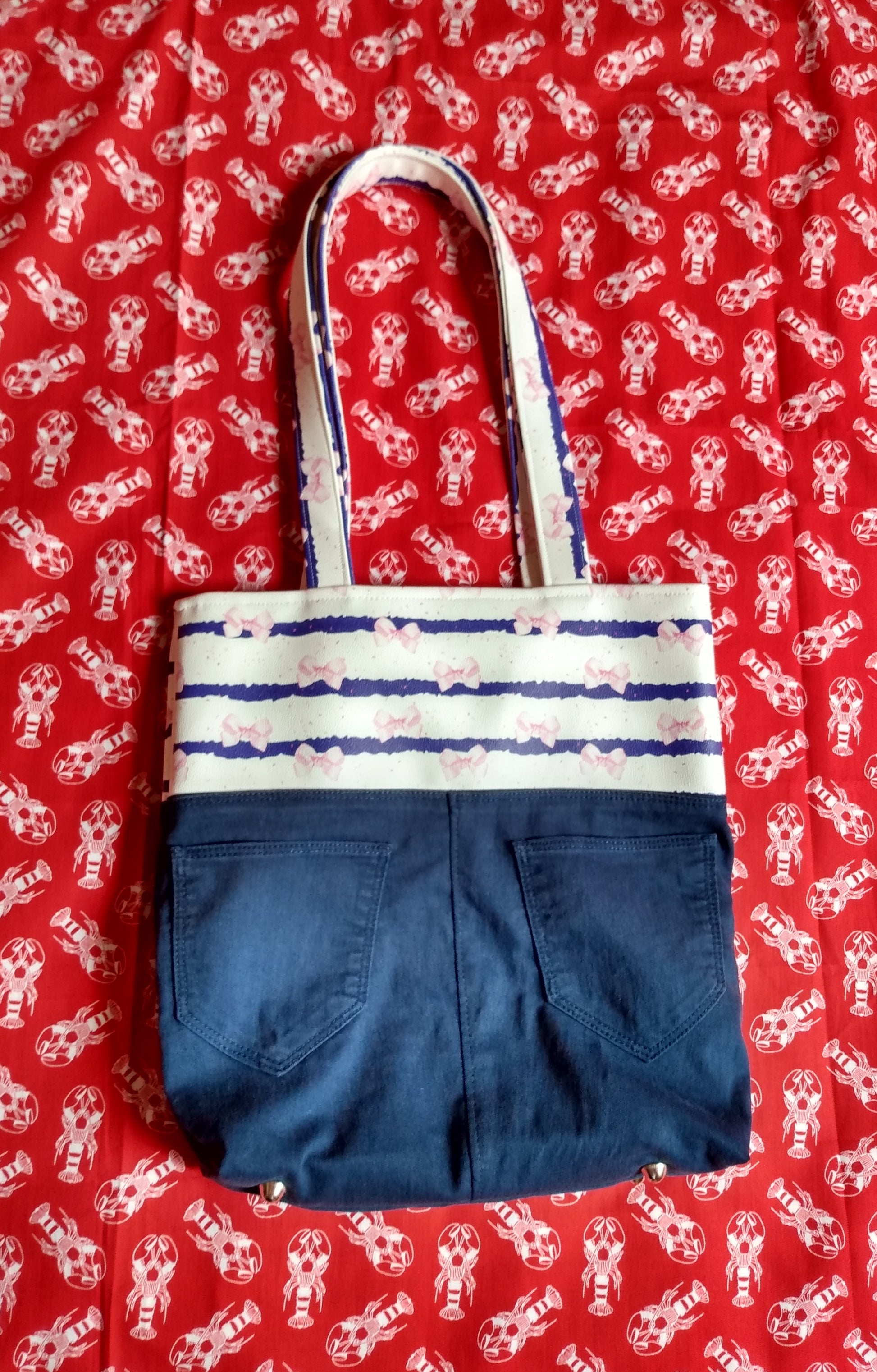 Autre vue de l'arrière du sac Jeanie. On aperçoit des pieds de sac en métal nickelé sur le dessous du sac.
