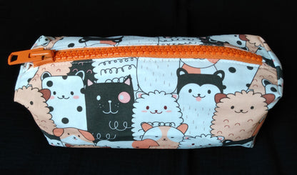 Trousse taille 2. Coton imprimé chiens saumon blanc et noir. La fermeture éclair est en plastique et métal orange.