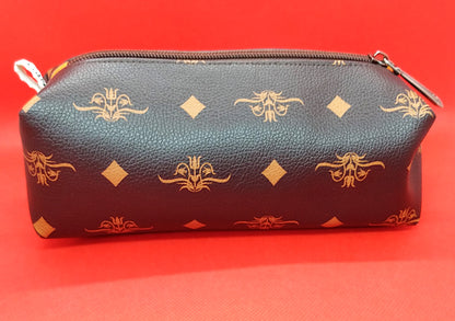 Trousse taille 1 simili cuir marron foncé à fleurs et losanges orangés. Se ferme par une fermeture éclair marron. L'étiquette "CdN" de la marque est présente sur un côté de la trousse.