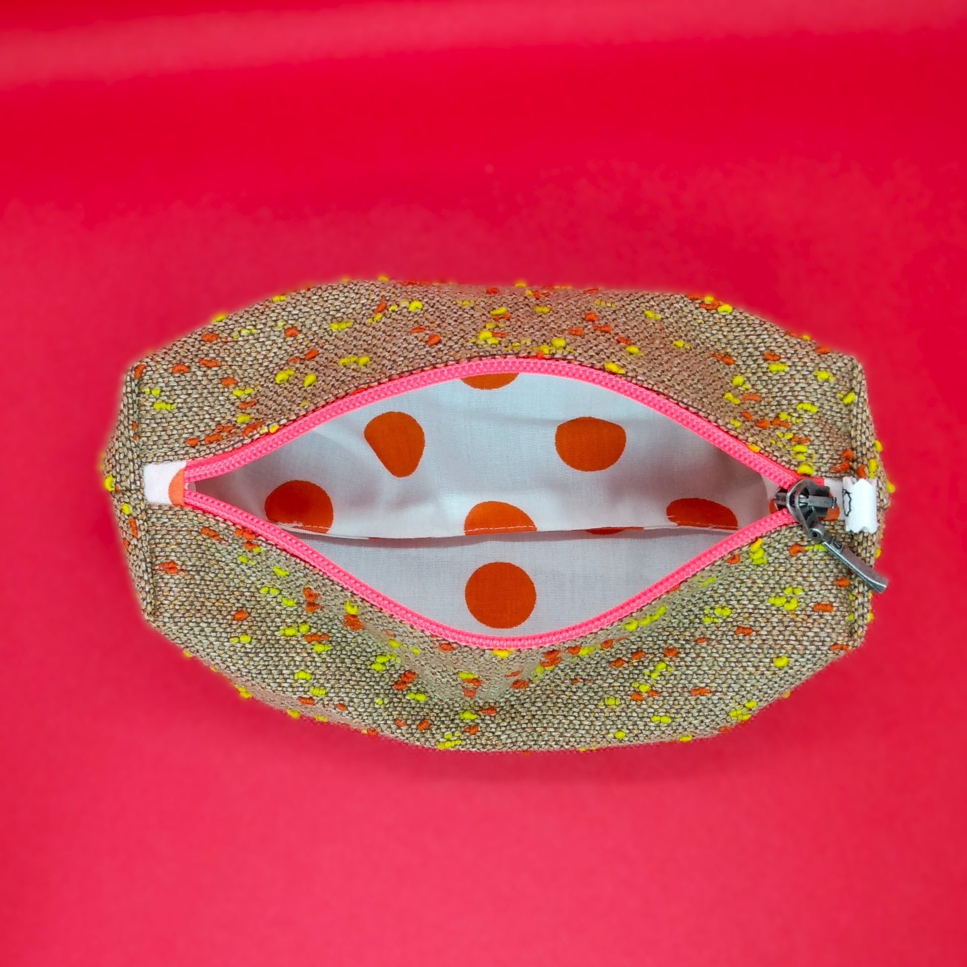 Trousse camel à pois orange et jaune ouverte. On voit donc l'intérieur qui est en coton blanc à pois oranges.