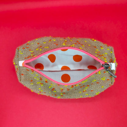 Trousse camel à pois orange et jaune ouverte. On voit donc l'intérieur qui est en coton blanc à pois oranges.