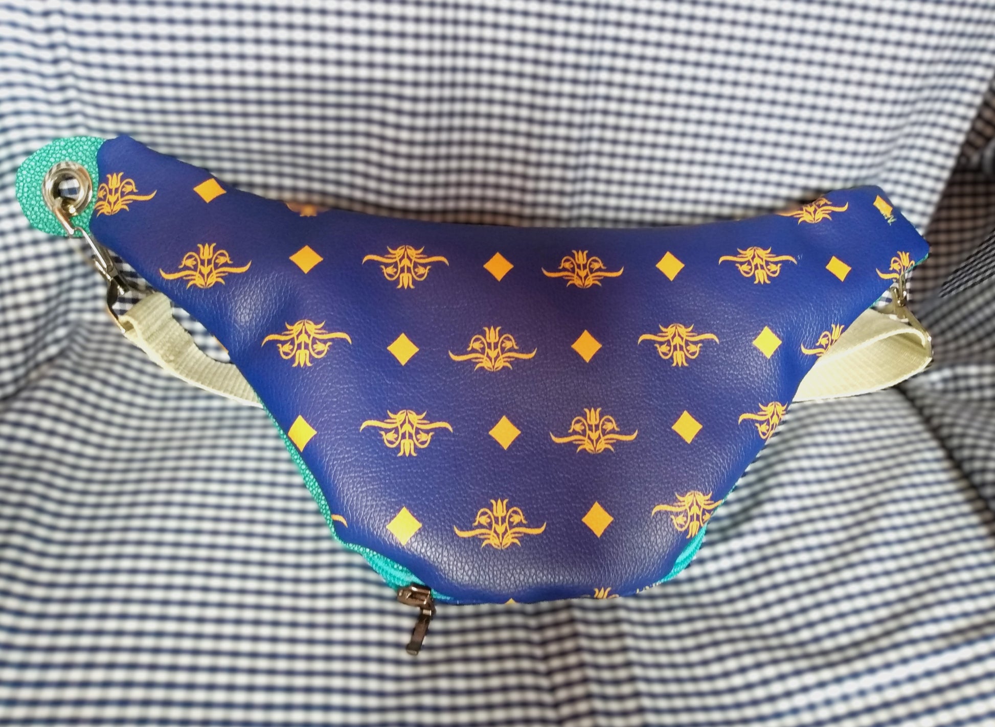 Arrière du sac banane Mango version bleue. Vue avant du sac banane Mango version bleue. L'extérieur arrière est en simili cuir bleu roi à motifs fleurs et losanges jaunes. 