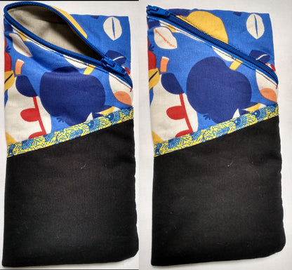 Étui à lunettes motifs pommes multicolore sur fond bleu. Se ferme avec un zip bleu. A l'extérieur, une poche noire ouverte, surmontée d'un biais jaune motif éventails bleus est visible à l'avant, sur la moitié basse de l'étui. L'intérieur est uni gris.