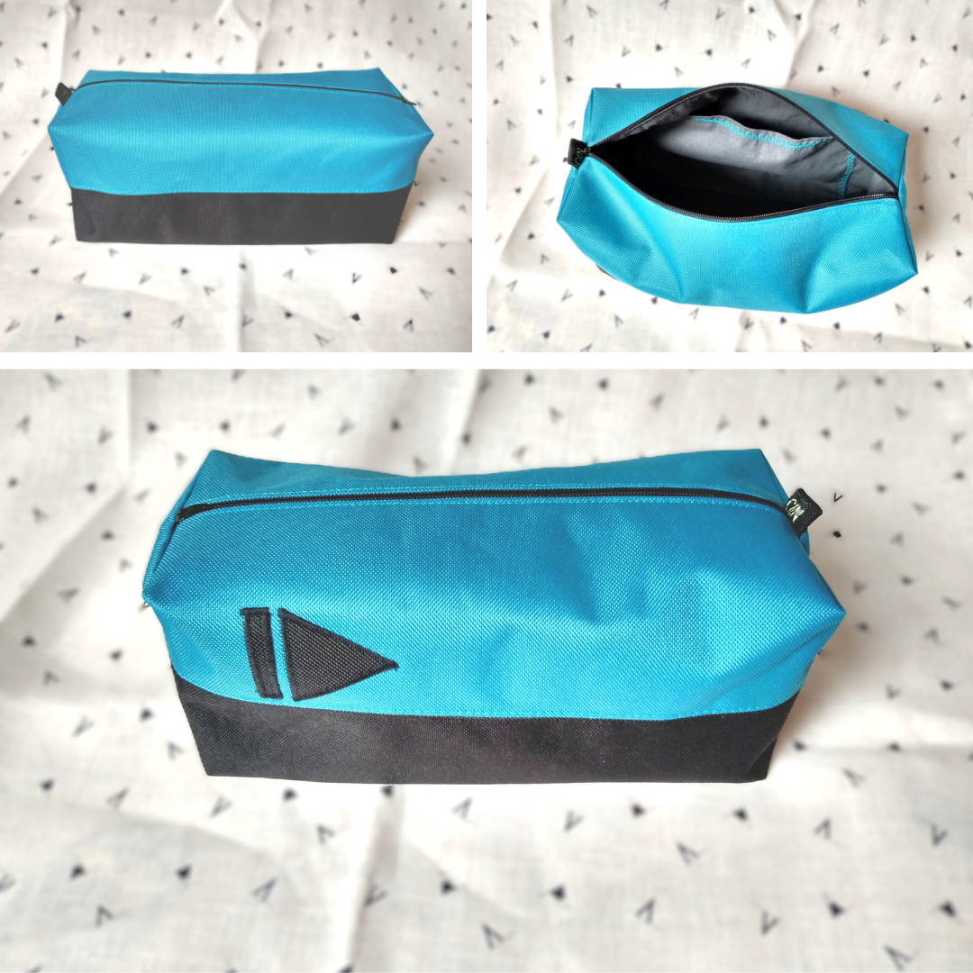 Trois vues de la trousse corail bleu paon et noir. 1) vue de l'arrière de la trousse bicolore ligne noire en bas et ligne bleu paon en haut. Se ferme avec un zip noir. 2) vue de l'intérieur de la trousse. La doublure est en coton gris anthracite et une poche plaquée grise avec un liseré bleu est visible. 3) avant extérieur de la trousse où l'on voit le symbole "suivant". Voir photo précédente pour plus de précision.