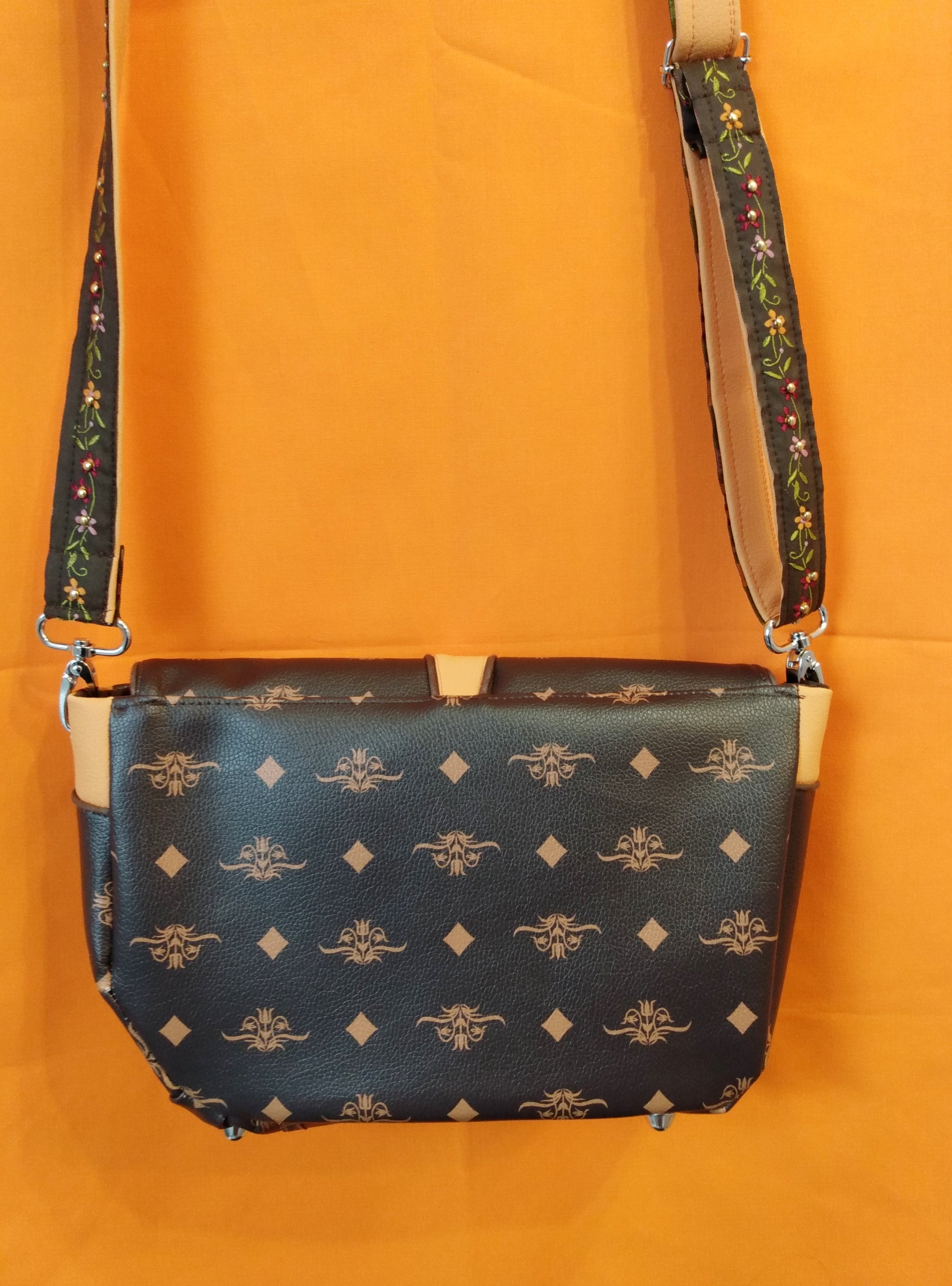 Arrière du sac Vegas marron foncé. Simili cuir marron foncé à motifs fleurs et losanges beiges.