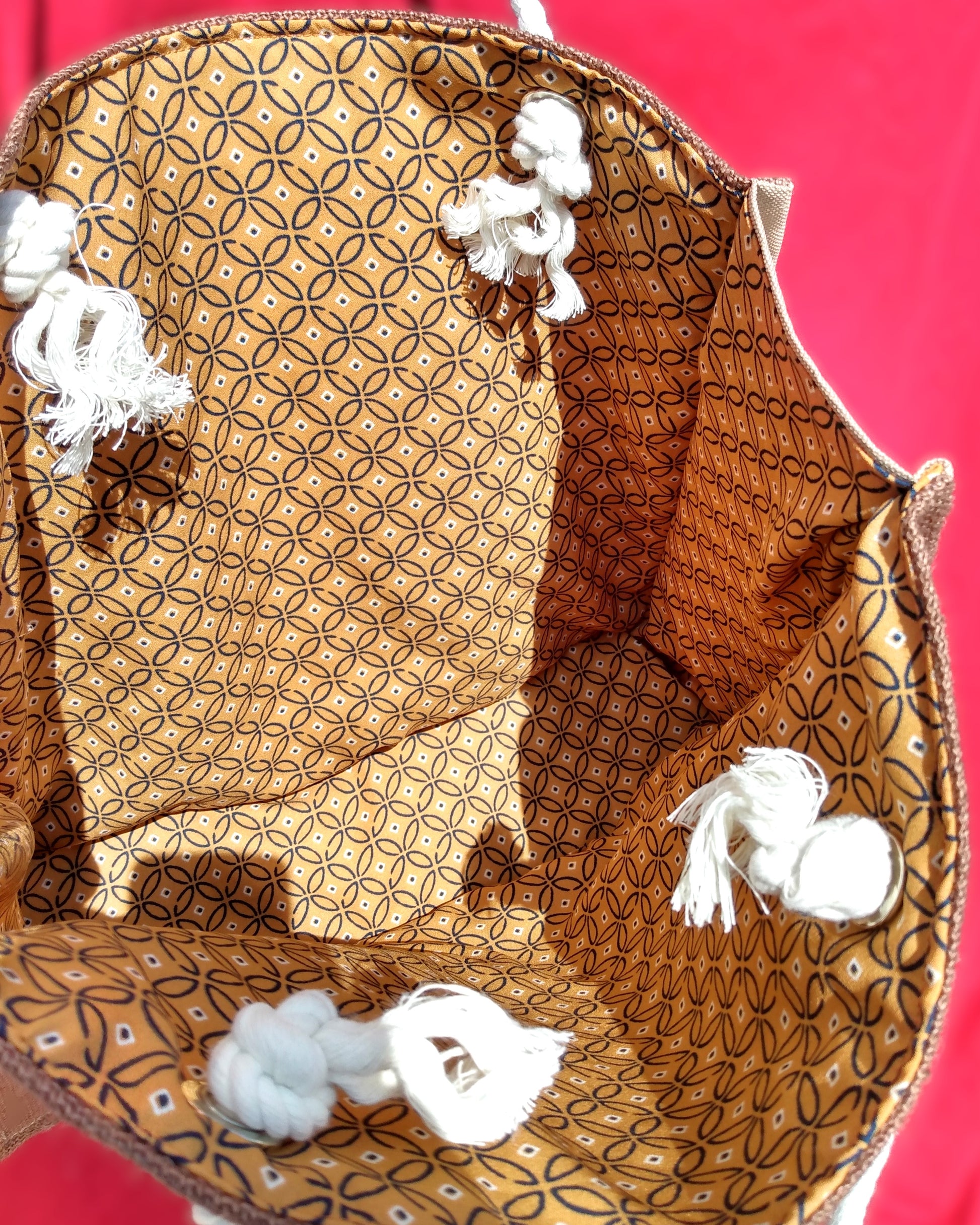 Intérieur du sac Peinard. La doublure est en coton châtain clair à motifs géométriques bleu marine. Les anses en corde sont attachées avec un œillet et bloquées par un nœud.